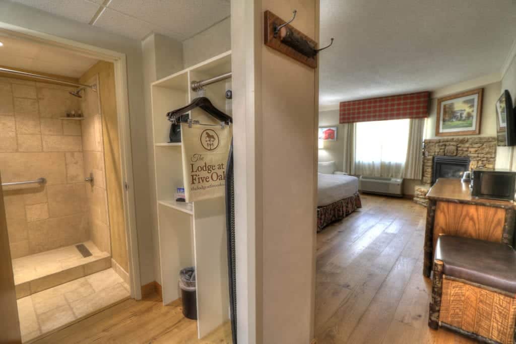 Walk in shower in spacious hotel room with fireplace at The Lodge at Five Oaks