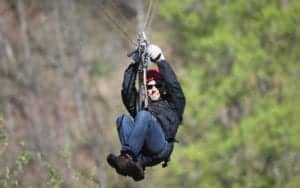 Man enjoying a thrilling ride on zipline attraction in Sevierville Tn