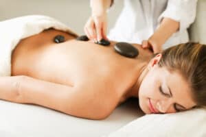 A woman enjoys a hot stone massage therapy treatment.