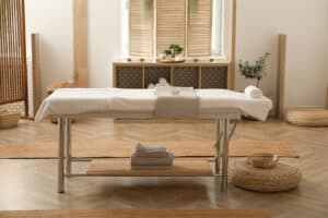 A massage treatment table stands in a spa room.